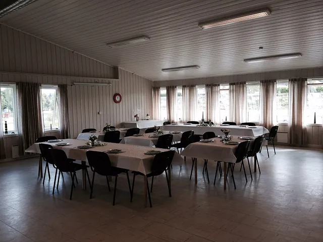 Storsalen med stoler og bord dekket til selskap