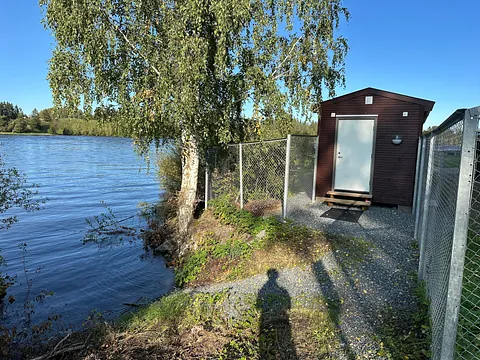 Brunt Badstu bygg ved siden av innsjø